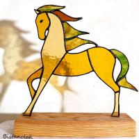 Cette décoration cheval est un objet vitrail coloré de ambre et vert.