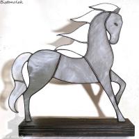 Cette décoration vitrail artisanale est un cheval gris à la crinière blanche.
