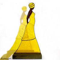 Cette décoration vitrail représente une femme africaine en robe jaune