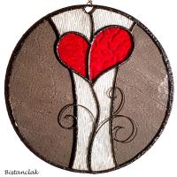 Cette décoration murale originale en vitrail représente un coeur stylisé rouge représenté comme une fleur sur un fond gris et translucide.