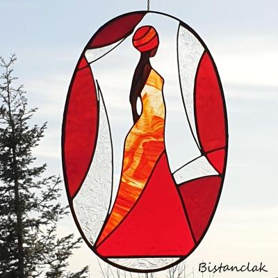 Ce vitrail de décoration ovale représente une femme africaine en robe rouge.